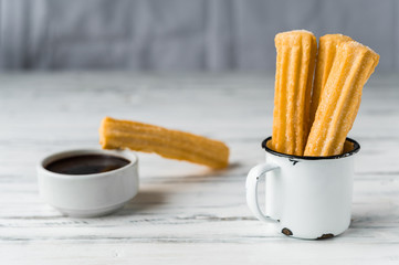 Churros with chocolate, a traditional Spanish sweet food pastry dessert, on white background