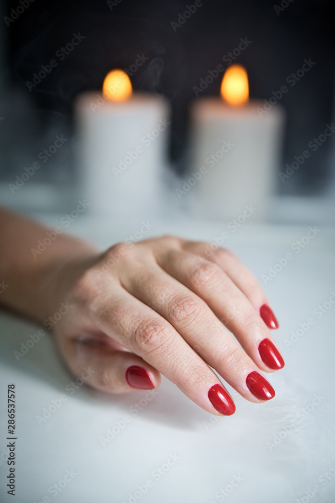 Wall mural red manicure, candles and smoke. salon manicure result