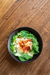 A bowl of nutritious and delicious oily noodles on a wooden tabletop