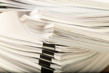 Stack of vintage document paper with black paperclip.