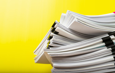 Stack of document paper with colorful paperclip.