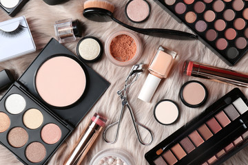 Set of different professional makeup products on furry plaid, flat lay