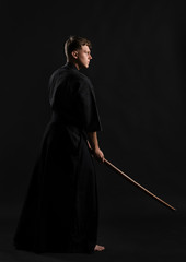Kendo guru wearing in a traditional japanese kimono is practicing martial art with the shinai...