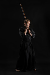 Kendo guru wearing in a traditional japanese kimono is practicing martial art with the shinai...