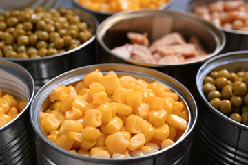 Open tin cans with conserved products, closeup