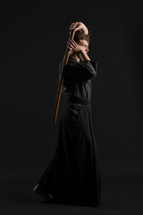 Kendo guru wearing in a traditional japanese kimono is practicing martial art with the shinai...