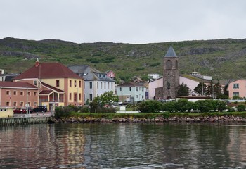 Fototapeta na wymiar view from the ocean towards the harbor front and cathedral at Saint Pierre, Saint Pierre and Miquelon