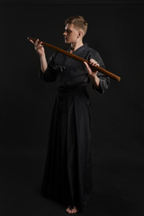 Kendo guru wearing in a traditional japanese kimono is practicing martial art with the shinai...