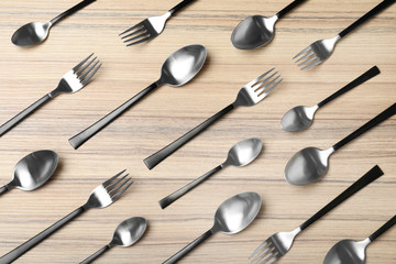 Set of new luxury cutlery on wooden table, flat lay