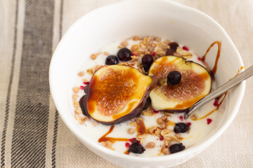 breakfast cereal with fig yogurt and berries on a white background