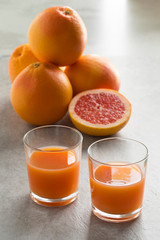 Whole and halved red grapefruit