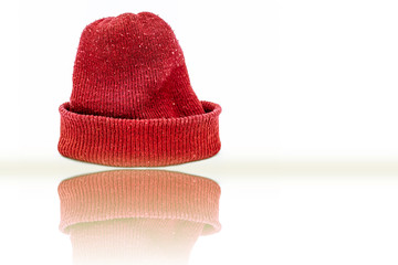Hand knitted red-colored woolen cap isolated on white indicating Christmas.
