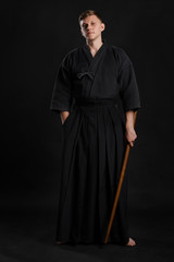 Kendo guru wearing in a traditional japanese kimono is practicing martial art with the shinai...