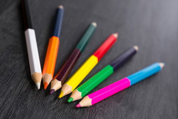 Colored pencils isolated on dark wooden background