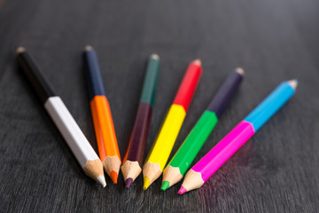 Colored pencils isolated on dark wooden background