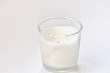 Used white candle light in a glass on white background with softly style 