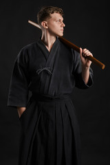 Kendo guru wearing in a traditional japanese kimono is practicing martial art with the shinai...