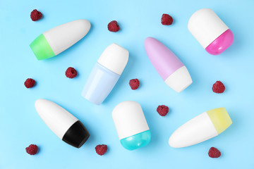 Flat lay composition with different female roll-on deodorants on light blue background