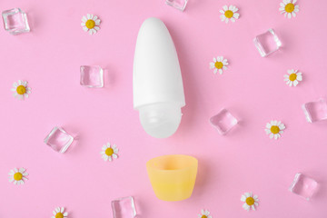 Flat lay composition with natural female roll-on deodorant on pink background