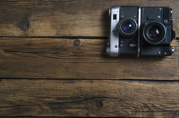 Old photo camera on wooden background, top view