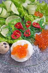 Fototapeta na wymiar fresh gourmet salad with red salmon caviar and chuka, eggs and vegetables. close up. Protein luxury delicacy healthy food. flat lay