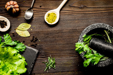 garlic, fresh salad and spices on wooden background top view