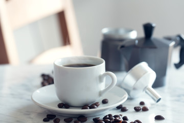 Hot cup of espresso or americano coffee in a traditional white cup on a table