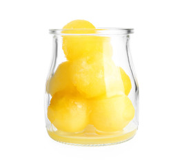 Glass jar of melon balls on white background
