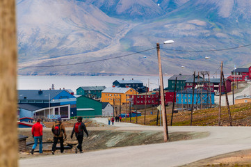 Tourists walking along a road in the town of Longyearbyen, Svalbard, Norway