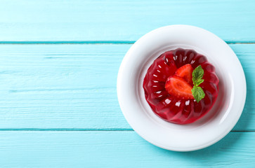 Delicious red jelly with strawberry and mint on light blue wooden table, top view. Space for text © New Africa