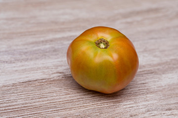 Several ecological tomatoes on a wooden table 