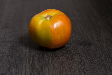 Several ecological tomatoes on a wooden table 