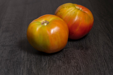Several ecological tomatoes on a wooden table 