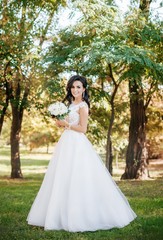 Beautiful brunette bride with stylish make-up in white dress