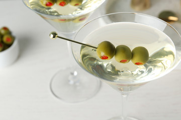 Glasses of Classic Dry Martini with olives on wooden table, closeup