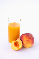 glass of peach juice and fresh fruits isolated on white