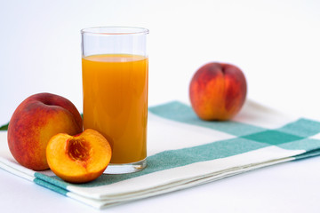 fresh peach and glass of juice on white background