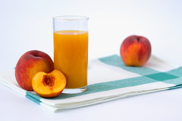 fresh peach and glass of juice on white background