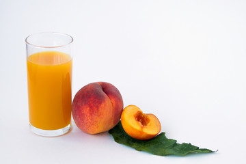 glass of peach juice and fresh fruits with green leaf isolated on white background
