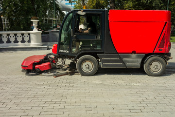 Fototapeta na wymiar Urban cleaning process. Special vehicle washes city street or park. Ecology and pure air in modern megalopolis concept. Technology of municipal services