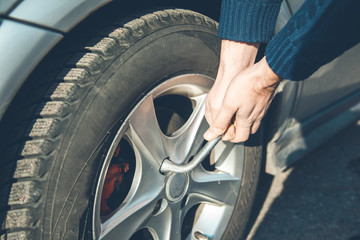 car mechanic screwing a car wheel