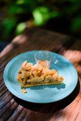 Apple pie on a wooden table in the garden