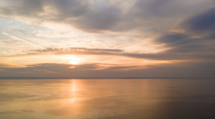 Obraz premium Beautiful view of the sea and sunset. Aerial view from flying drone of a beautiful nature landscape with dramatic clouds sunset sky and views of the sea surface. Postcard view. Nature