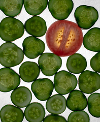 Beautiful, green, red, glowing slices of cucumber and tomato slice, lying on a white background. Cucumber and tomato slices, translucent flash.