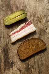 Bacon, bread and cucumber over wooden background. Russian and ukrainian traditional appetizer