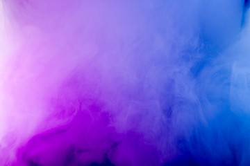 Thick smoke in the neon light. Pink and blue light, texture, background. Out of focus. Abstract dark background.