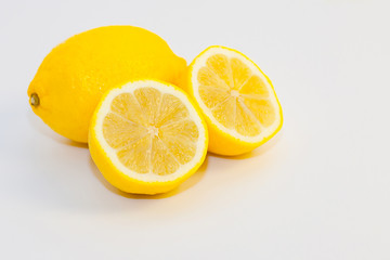 lemons and lemon slices on white background
