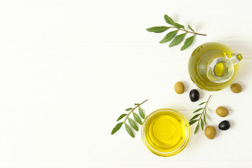 olive oil, green leaves and olives on the table top view.