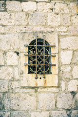 Fototapeta na wymiar vintage lattice on the window, element of architecture of St.George Island in Perast on shore of Boka Kotor bay, Adriatic Sea, Montenegro