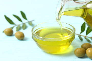 Olive oil, olives and green leaves.